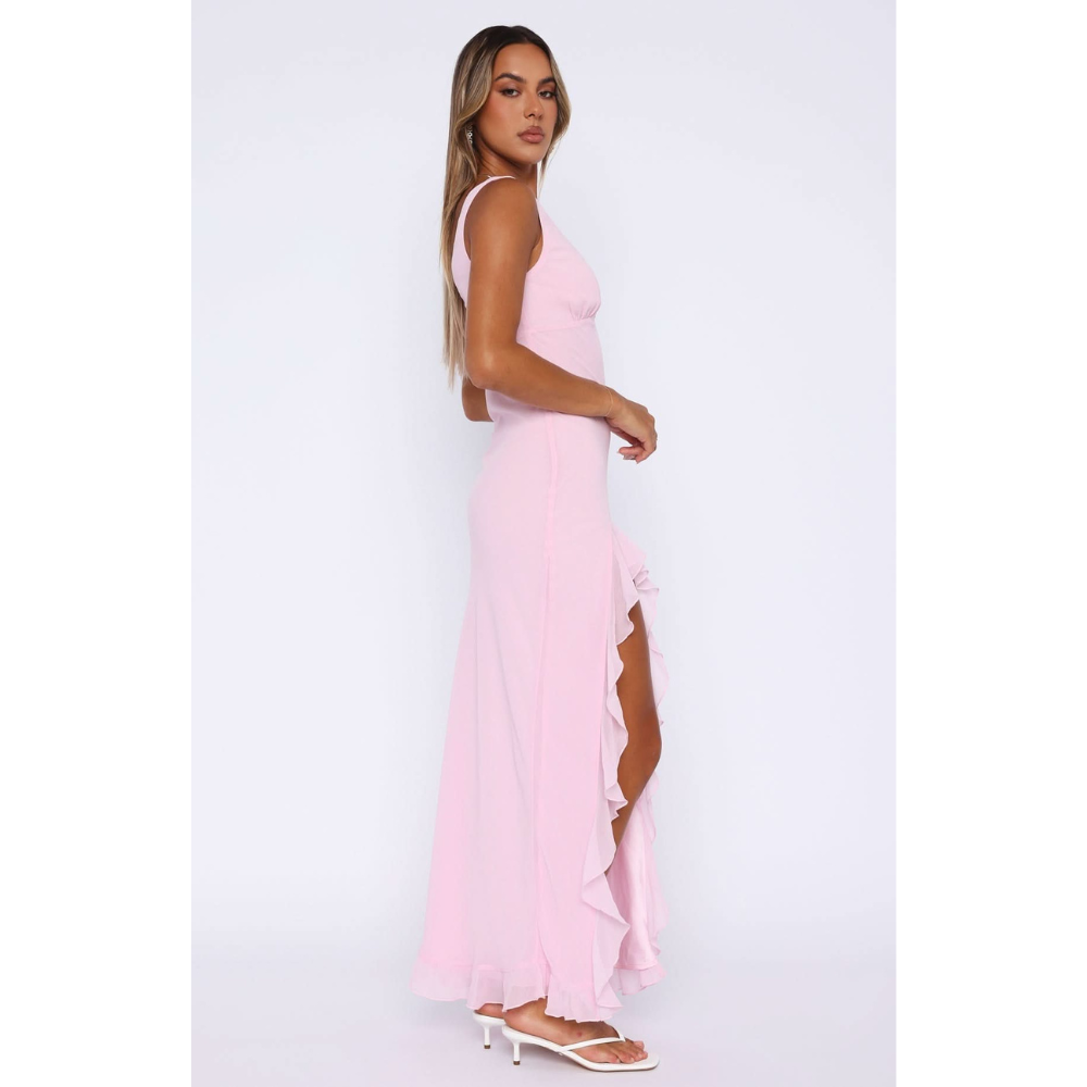 Side profile of pink maxi dress with flowing ruffled asymmetrical skirt