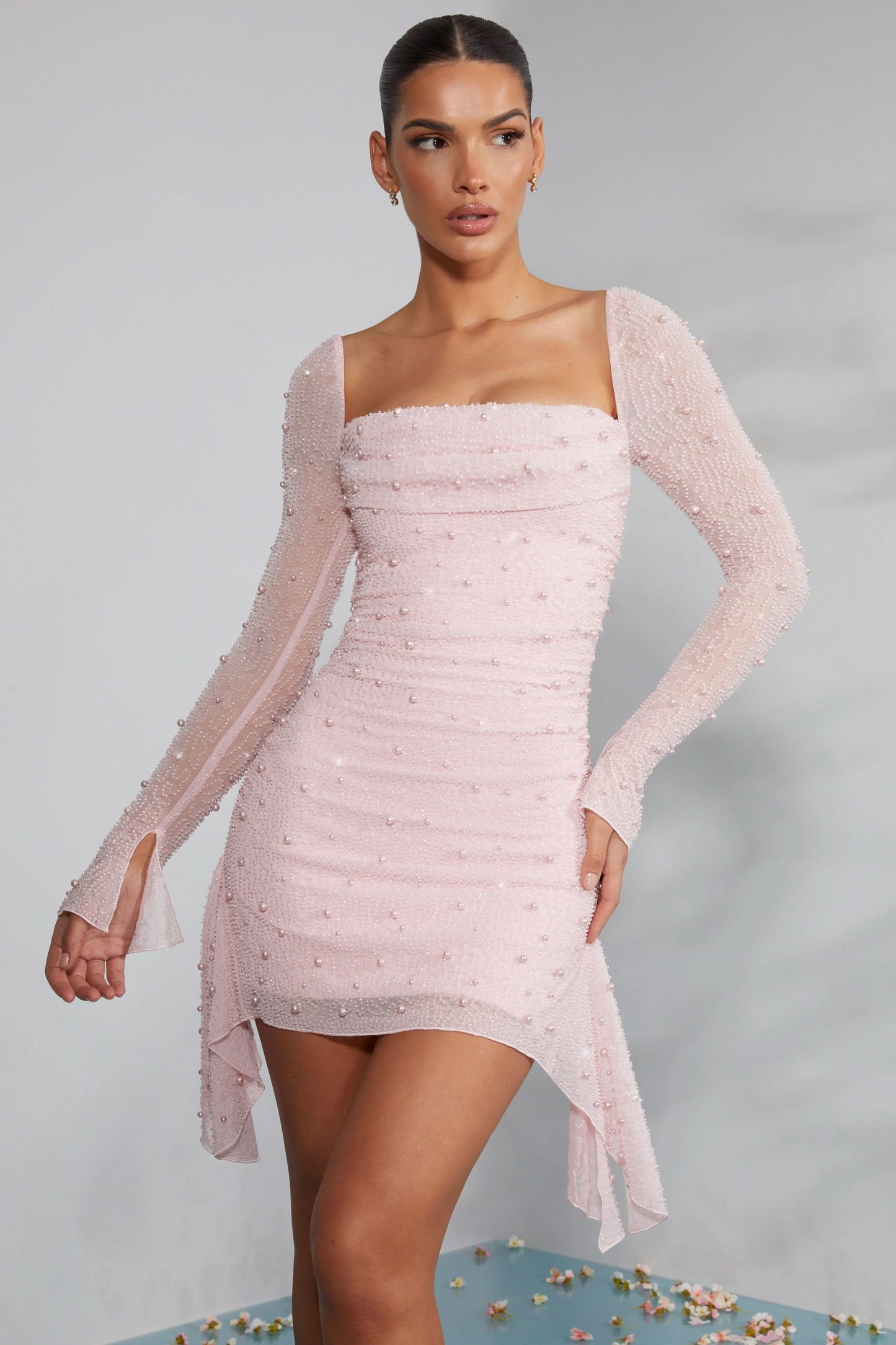 Pink beaded mini dress front view with long sheer sleeves and slit details
