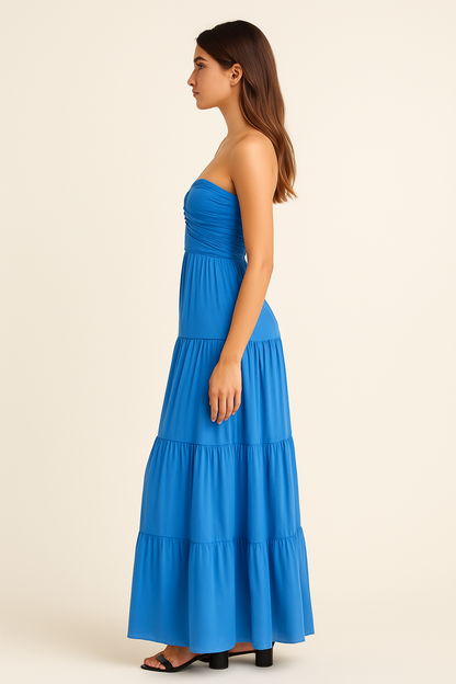 Side view of women's cobalt strapless maxi dress showing elegant tiered layers and cascading pleats