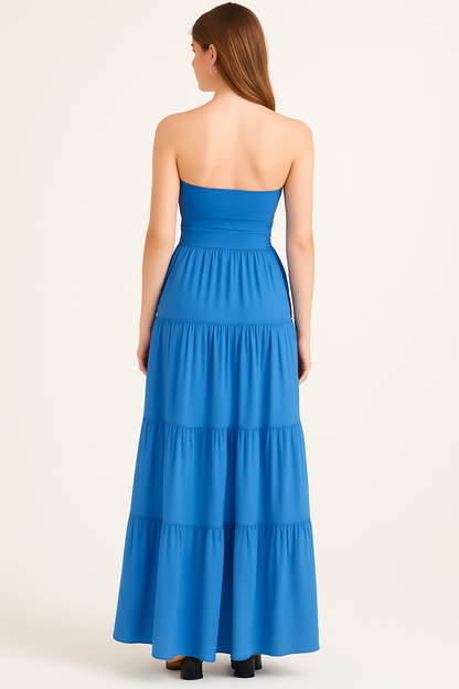 Back view of blue strapless dress highlighting open back design and cascading pleated skirt