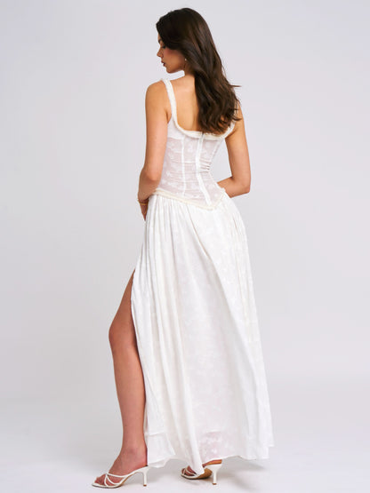 Back view of white maxi dress with corset-style bodice and flowing skirt
