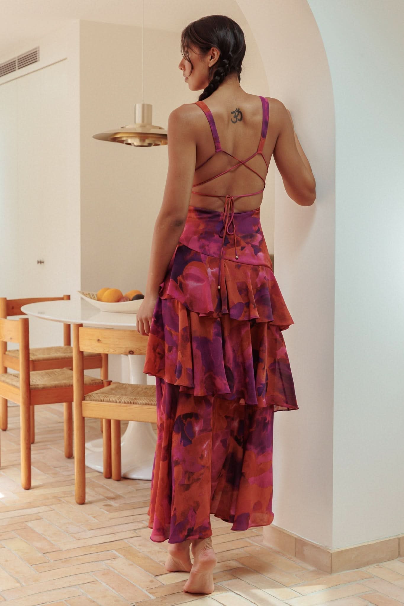 Back view of red tie-dye ruffle midi dress with crisscross back straps and tiered ruffles