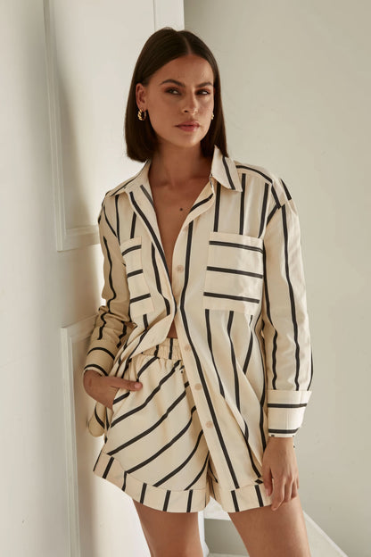 Front view of cream and black striped knit shirt with button details