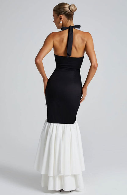 Back view of black halter maxi dress with open back and white tiered ruffle skirt