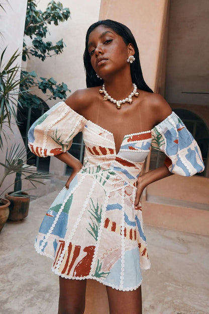 Off-shoulder puff sleeve mini dress with blue, red, and green print and pearl trim