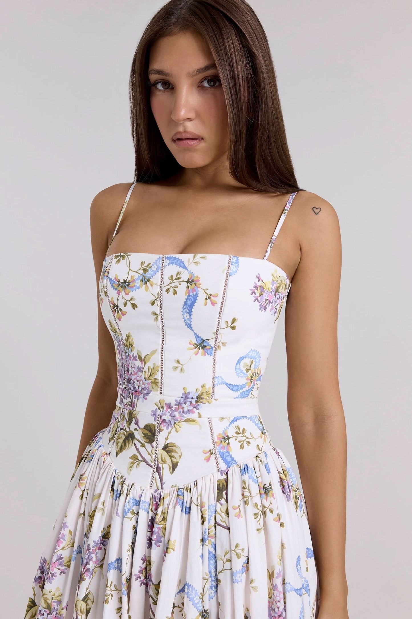 Fitted bodice detail of white midi dress with purple lilac and blue ribbon print