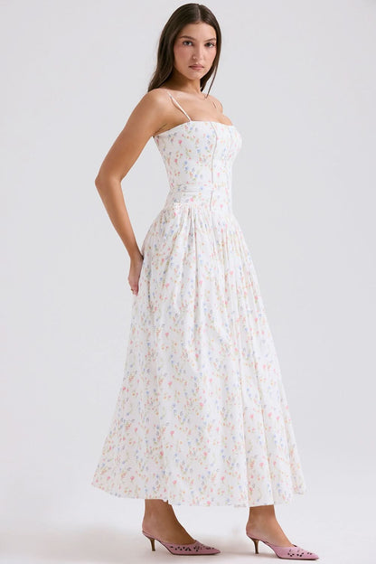 Side view of cream floral midi dress with spaghetti straps and gathered skirt