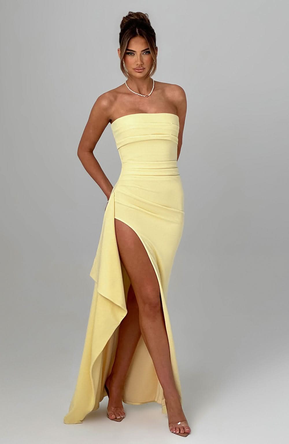 Pale yellow strapless maxi dress with asymmetrical hem detail