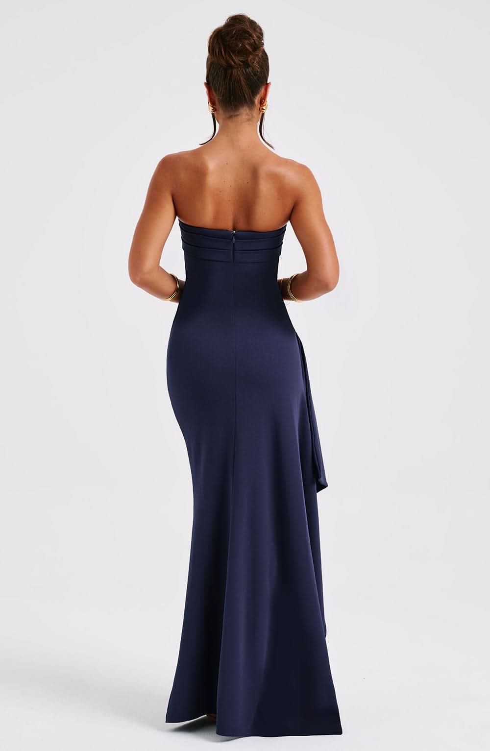 Back view of navy strapless maxi dress with flowing train