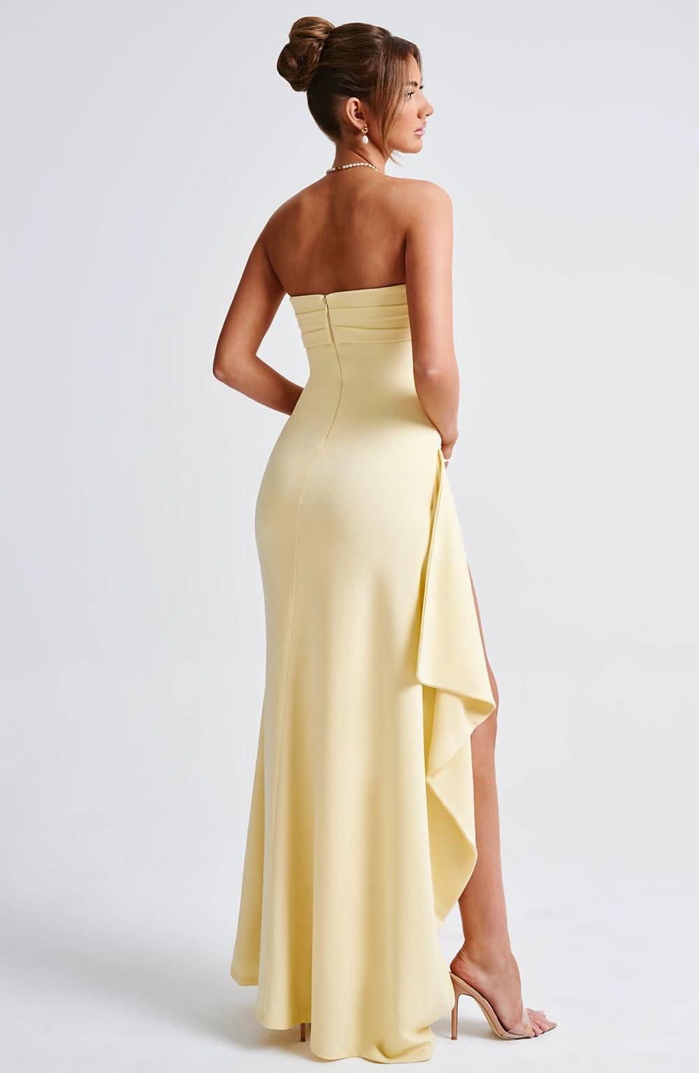 Pale yellow strapless maxi dress with ruched bodice and slit